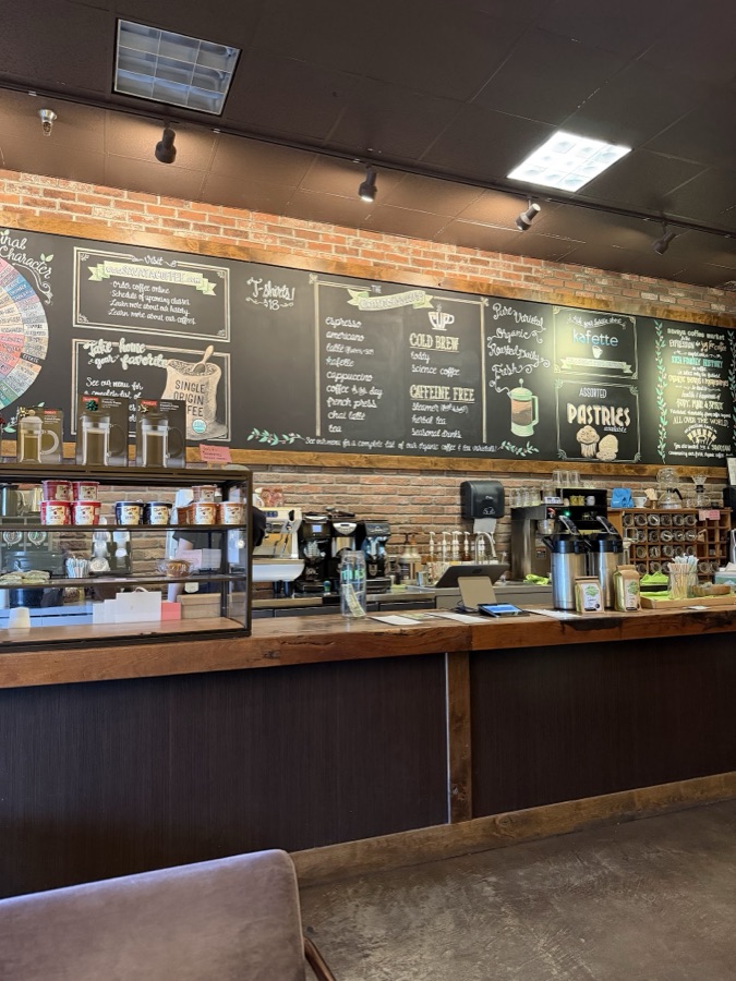 The chalkboard menu behind the counter listing espresso, cold brew and more.